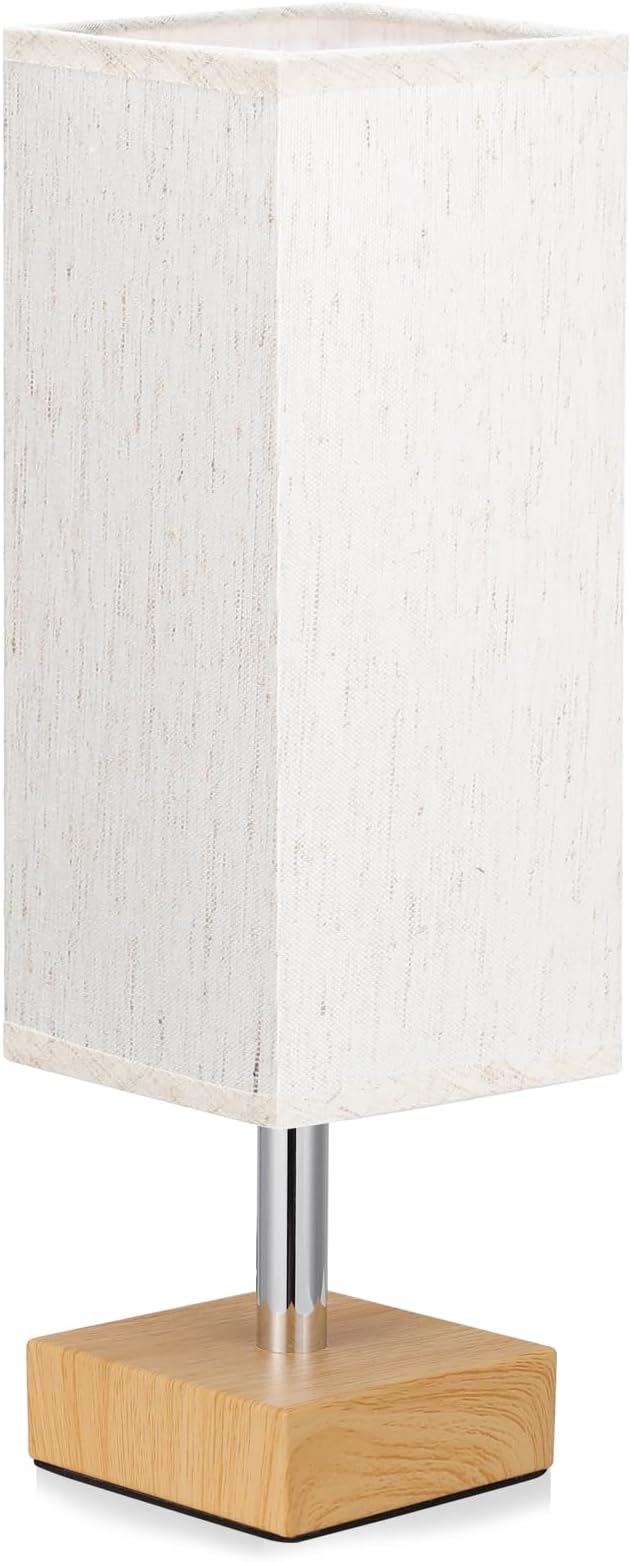 Table lamp with a wooden base and white fabric shade on a white background